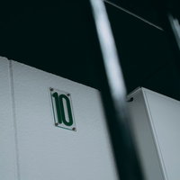 ビルの白い壁面に取り付けられた10階を示すプレートの写真
