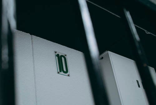 ビルの白い壁面に取り付けられた10階を示すプレート