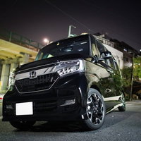 夜の駐車場に停車する黒いワンボックス軽自動車の写真