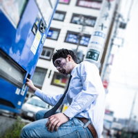 自販機前でしゃがむゾンビメイクの男性の写真