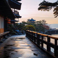 日本風の長屋が並ぶ夜明けの通り、朝日に照らされた石畳と庭園の写真