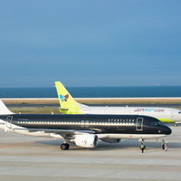 最終チェックをする飛行機の横を通り駐機場に向かう着陸機の写真