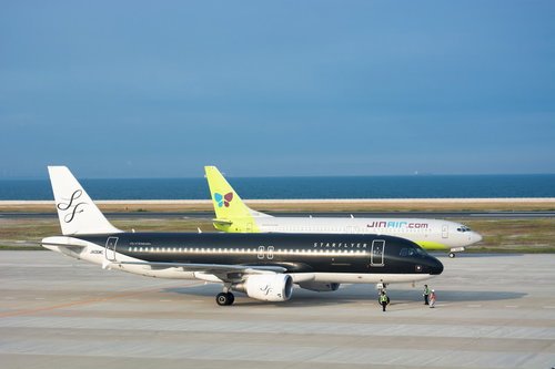 最終チェックをする飛行機の横を通り駐機場に向かう着陸機