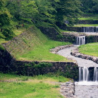整備された小川の段差を流れ落ちる水の写真