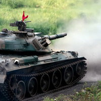 74式戦車と、発射直後に巻き上げられる土煙の写真