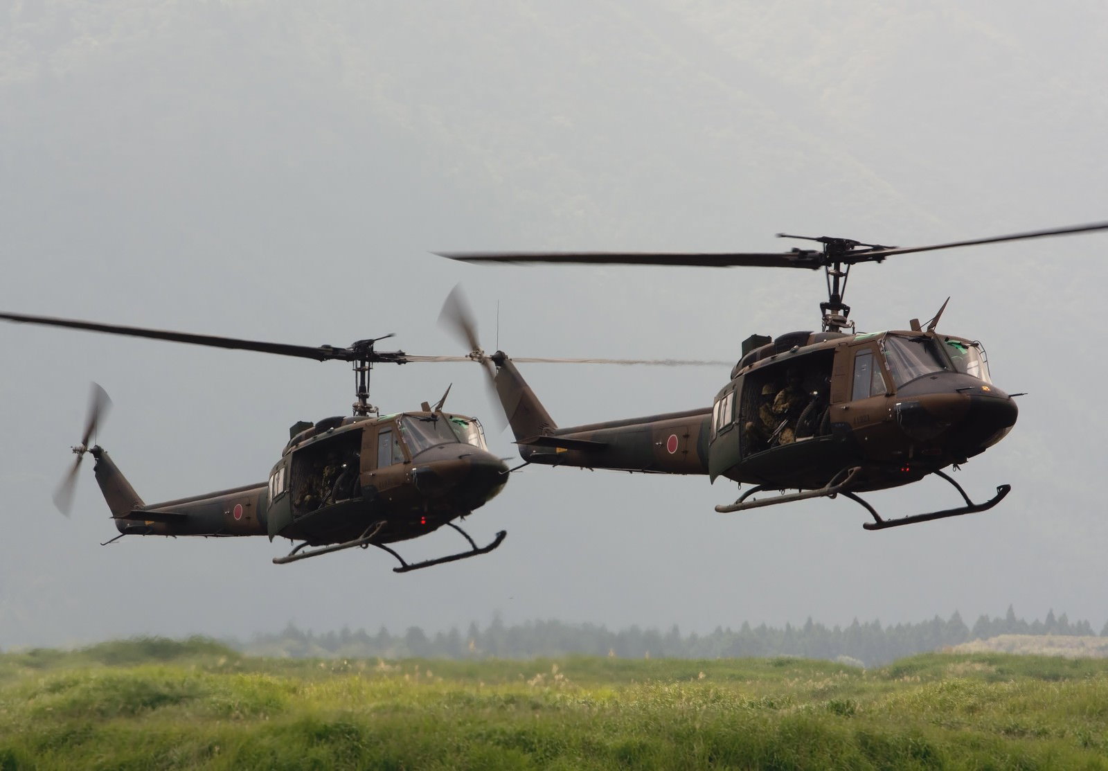 オートバイを搭載して飛行するUH-1ヘリ2機