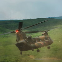 自らのダウンウォッシュで巻き上げた砂埃の中着陸するチヌーク（CH-47）の写真
