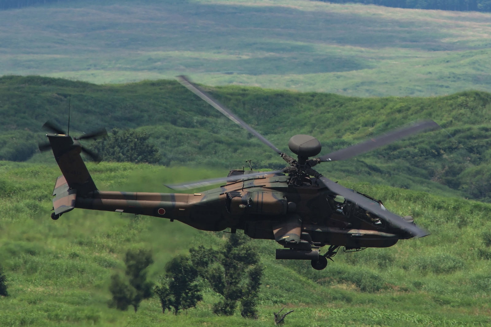 山間部上空を飛行する攻撃ヘリコプターアパッチ（AH-64）