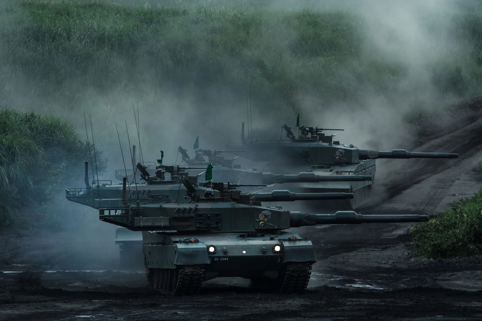 砂煙を上げながら進む緑色迷彩の90式戦車