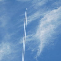 空に真っすぐ描かれた飛行機雲の写真