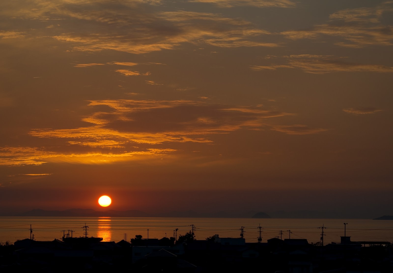 燧灘に沈む夕陽と鉄塔のシルエット