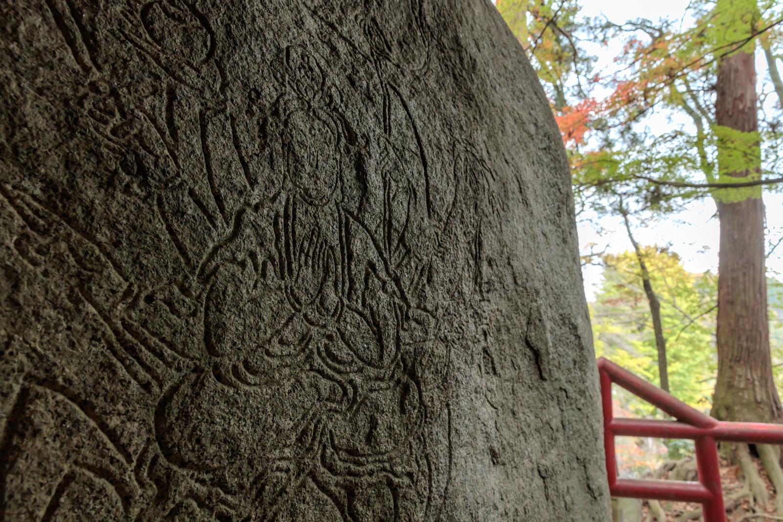 岩角寺の岩壁に彫刻された三十三観世音、深く刻まれた線で観音の姿が浮き彫りになっている