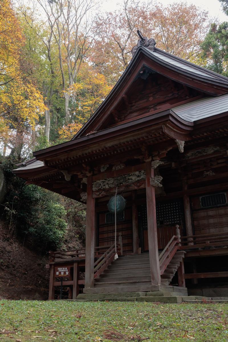 秋の紅葉に囲まれた木造の那智観音堂の外観