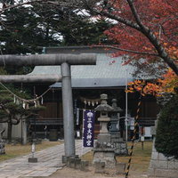 秋の参道を彩る三春神社の石造鳥居と社殿の写真