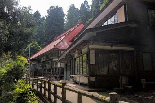 東堂山満福寺の参道へ向かう木製の柵と赤い瓦屋根の建物