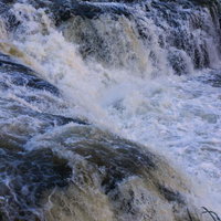 乙字ヶ滝の勢いよく流れ落ちる滝と水飛沫が舞う渓流風景の写真