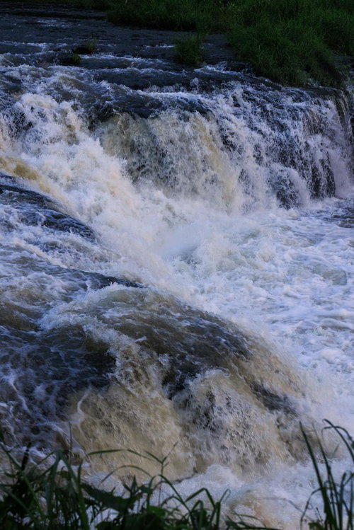 乙字ヶ滝の勢いよく流れ落ちる滝と水飛沫が舞う渓流風景
