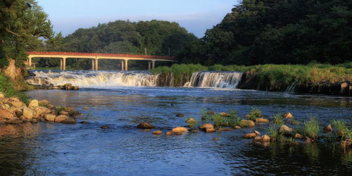 福島県玉川村の乙字ヶ滝越しに見る赤い乙字橋と豊かな自然