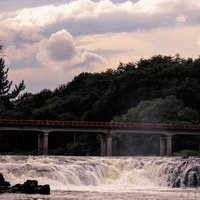 激流の乙字ヶ滝と赤い乙字橋の風情、玉川村の絶景の写真