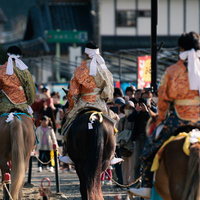 流鏑馬の馬上で白い襷をつけた3人の騎士、古殿八幡神社の神事の写真