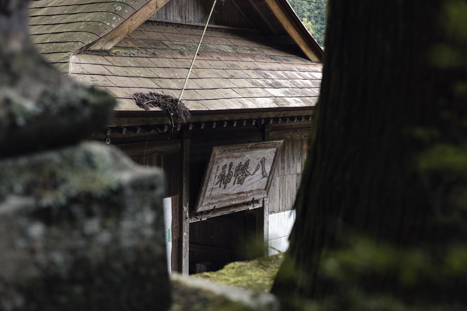 緑の木々に囲まれた古殿八幡神社の境内にある木造の拝殿
