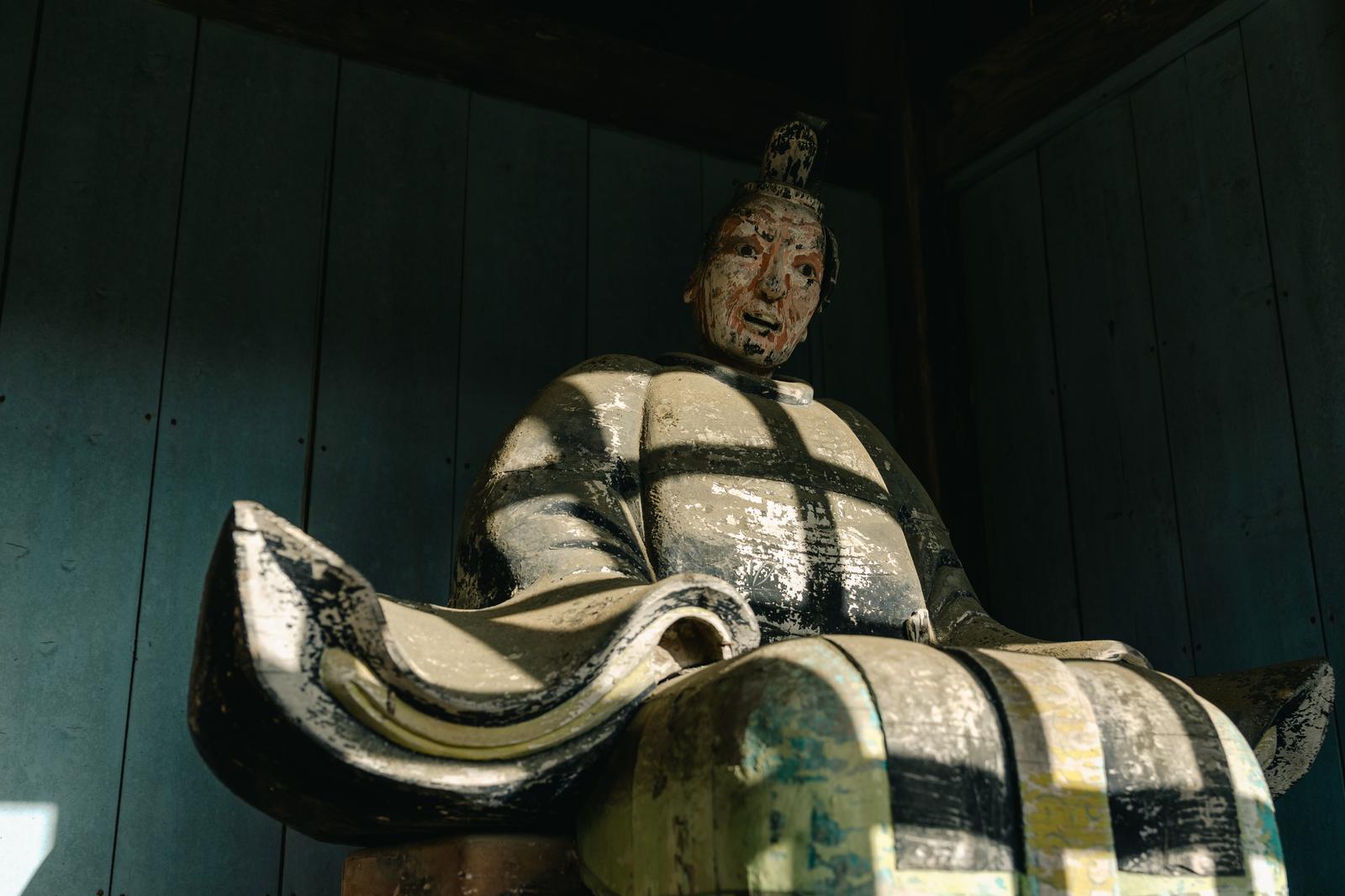 古殿八幡神社の境内に立つ装束を着た石造の像