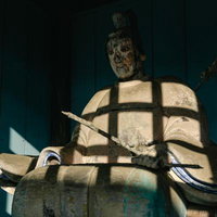 古殿八幡神社の境内に鎮座する風化した武士像の写真