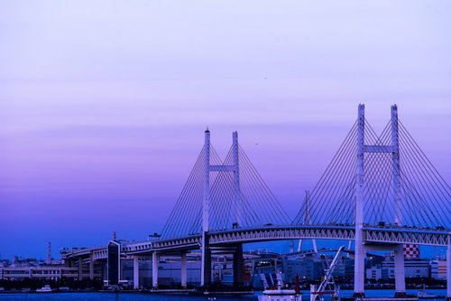 夕暮れ時の横浜ベイブリッジと工業港の都市夜景