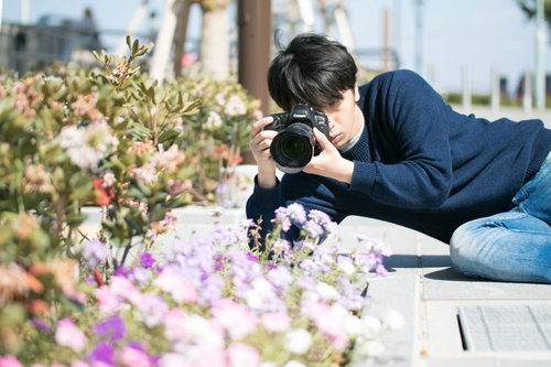 無意識のうちにほふく前進をするアマチュアカメラマン男性