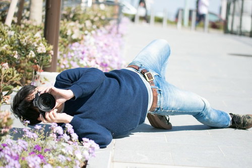 ローアングルでカメラを向けるカメラマンの撮影風景