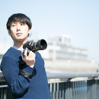 青空の下でカモメの飛行シーンを捉えるフォトグラファーの写真