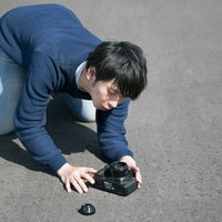 ストラップ忘れでカメラ落下させてしまう男性カメラマンの写真