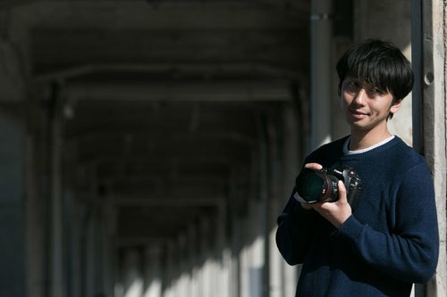 A grinning face watching a couple being affectionate in public