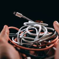 不要になったLightningケーブルと充電ケーブルの山の写真