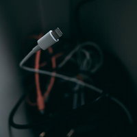 接続することを忘れられた白いLightningケーブルと充電機器の写真