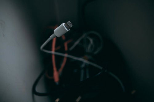 接続することを忘れられた白いLightningケーブルと充電機器