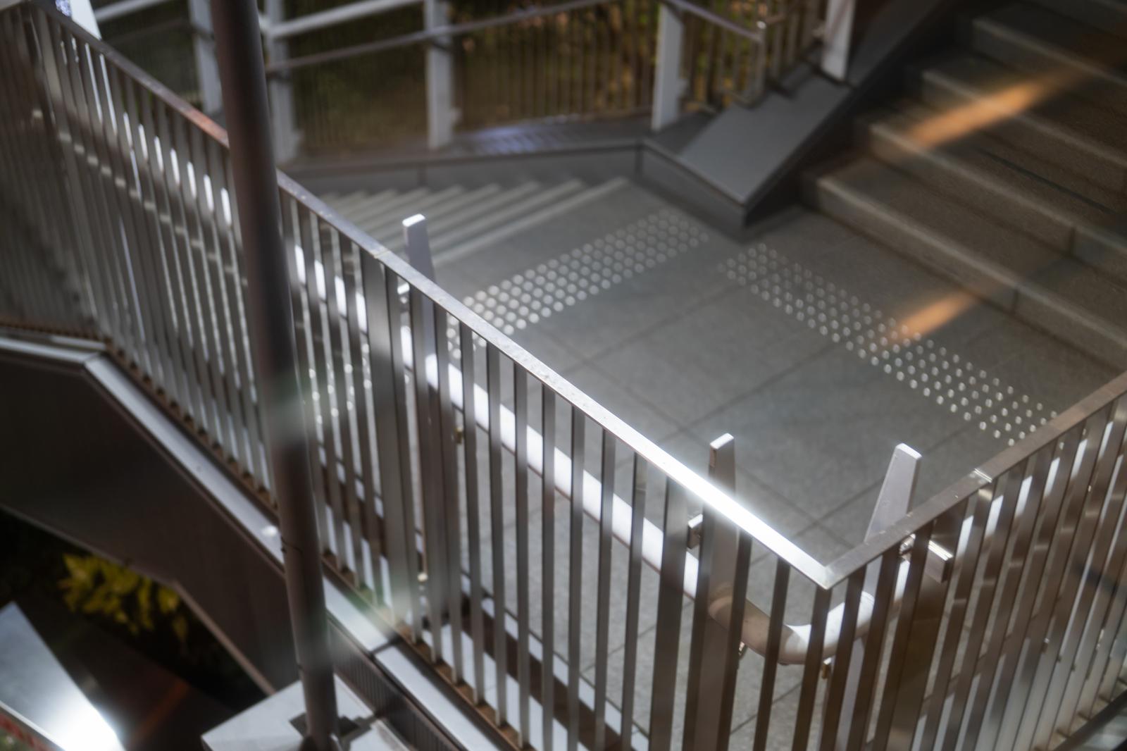 Metal railing with vertical lattice design and non-slip stairs.