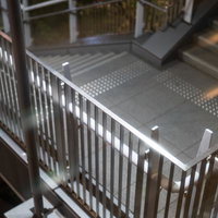 建物内の金属製階段と縦格子の手すりの写真