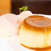 カラメルソースのかかったプリンとアイスの写真
