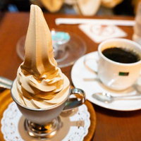 コーヒーカップにのせたバニラソフトクリームの写真