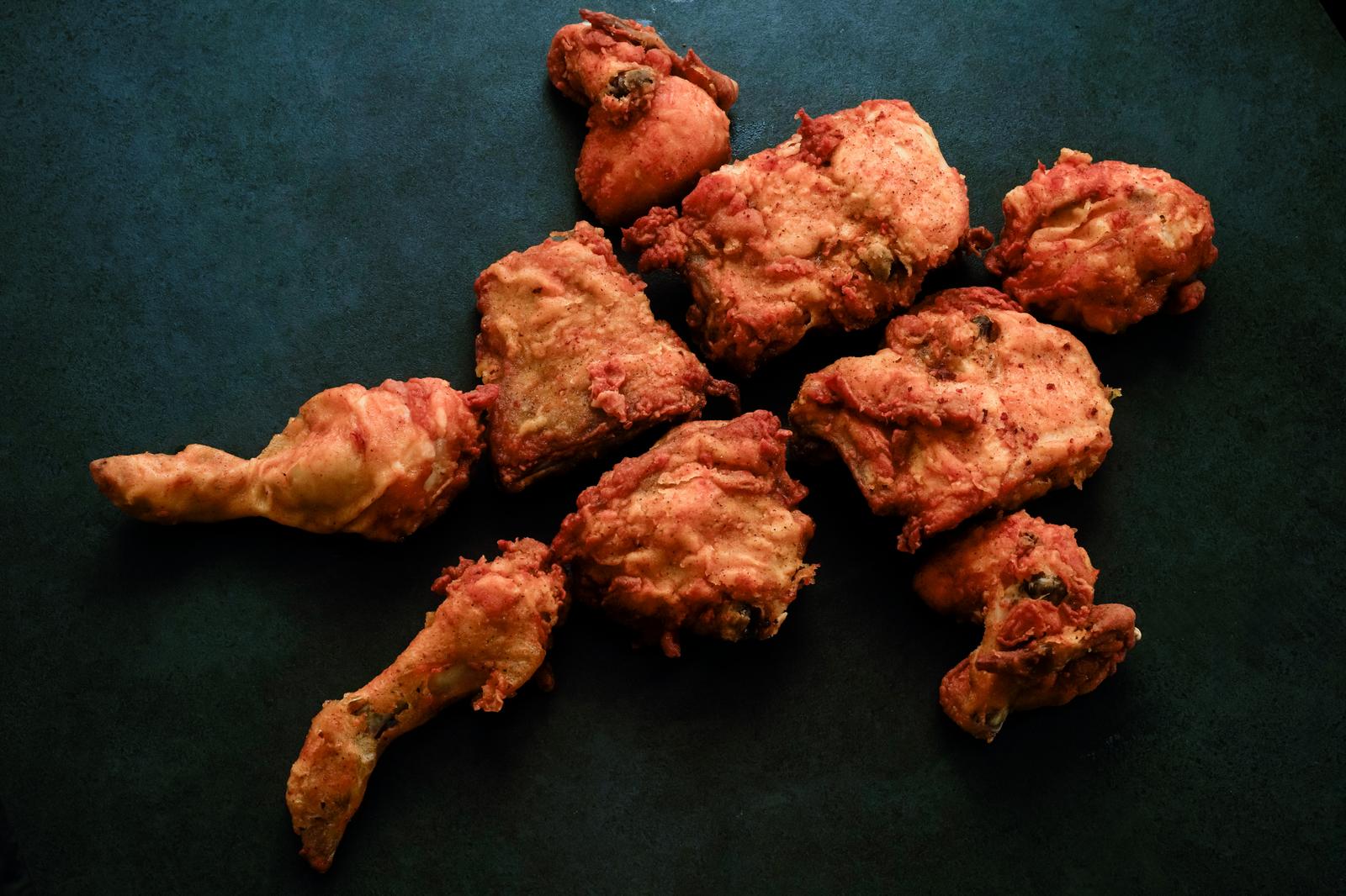 A platter of 10 pieces of fried chicken on a black background