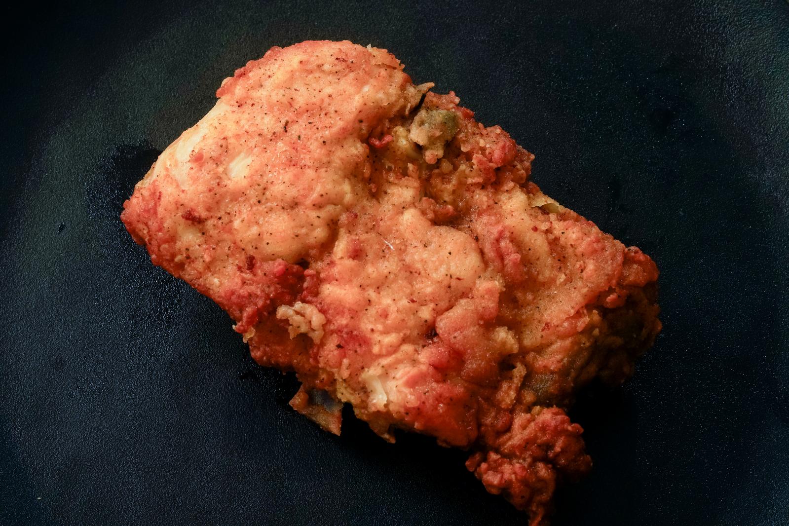 Crispy fried chicken arranged on a black plate