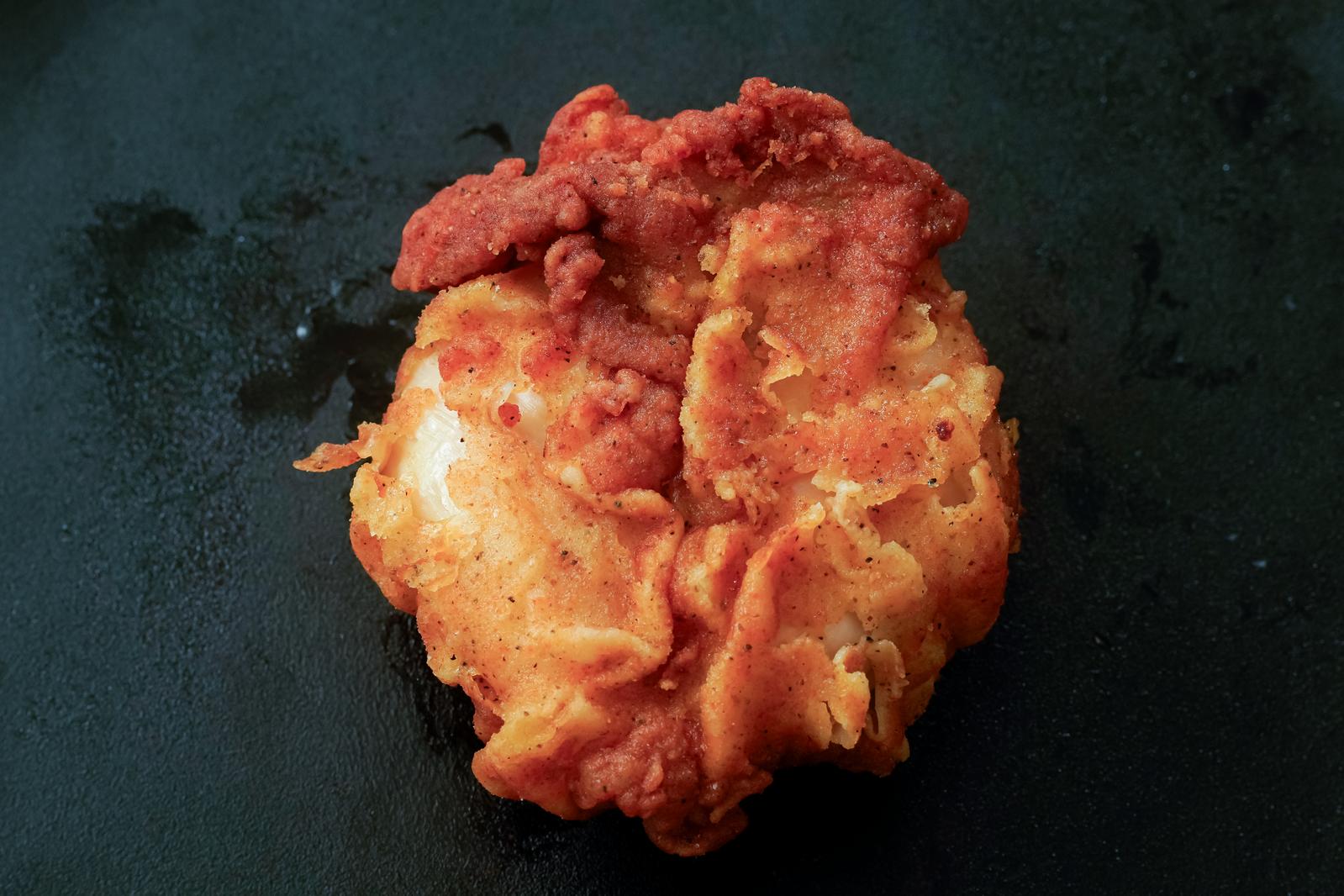 Crispy fried chicken with ribs on a black plate