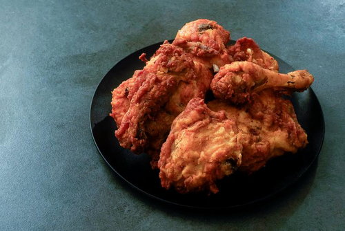 黒い皿に盛った骨付きジューシーな鶏の唐揚げ盛り合わせ