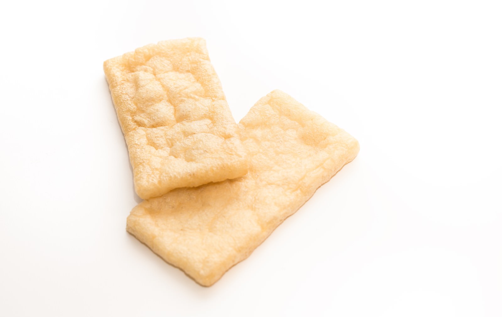 白い背景に重ねて置かれた油揚げ2枚
