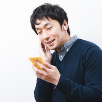 ワイヤレスイヤホンの音質に満足げな男性の写真