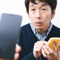 iPhoneと油揚げでAirDropを試す男性の写真