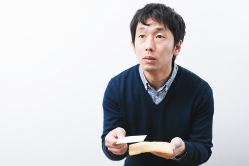 油揚げから名刺を取り出すエンジニア