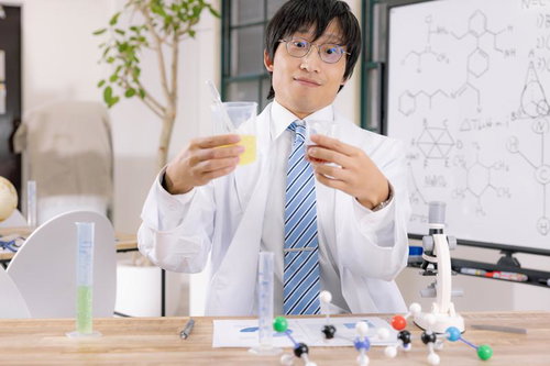 ビーカーの色味変化を確認して成功を喜ぶ研究員