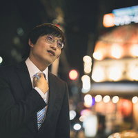 ネクタイを締めて夜の街で次の店へ向かう会社員の写真